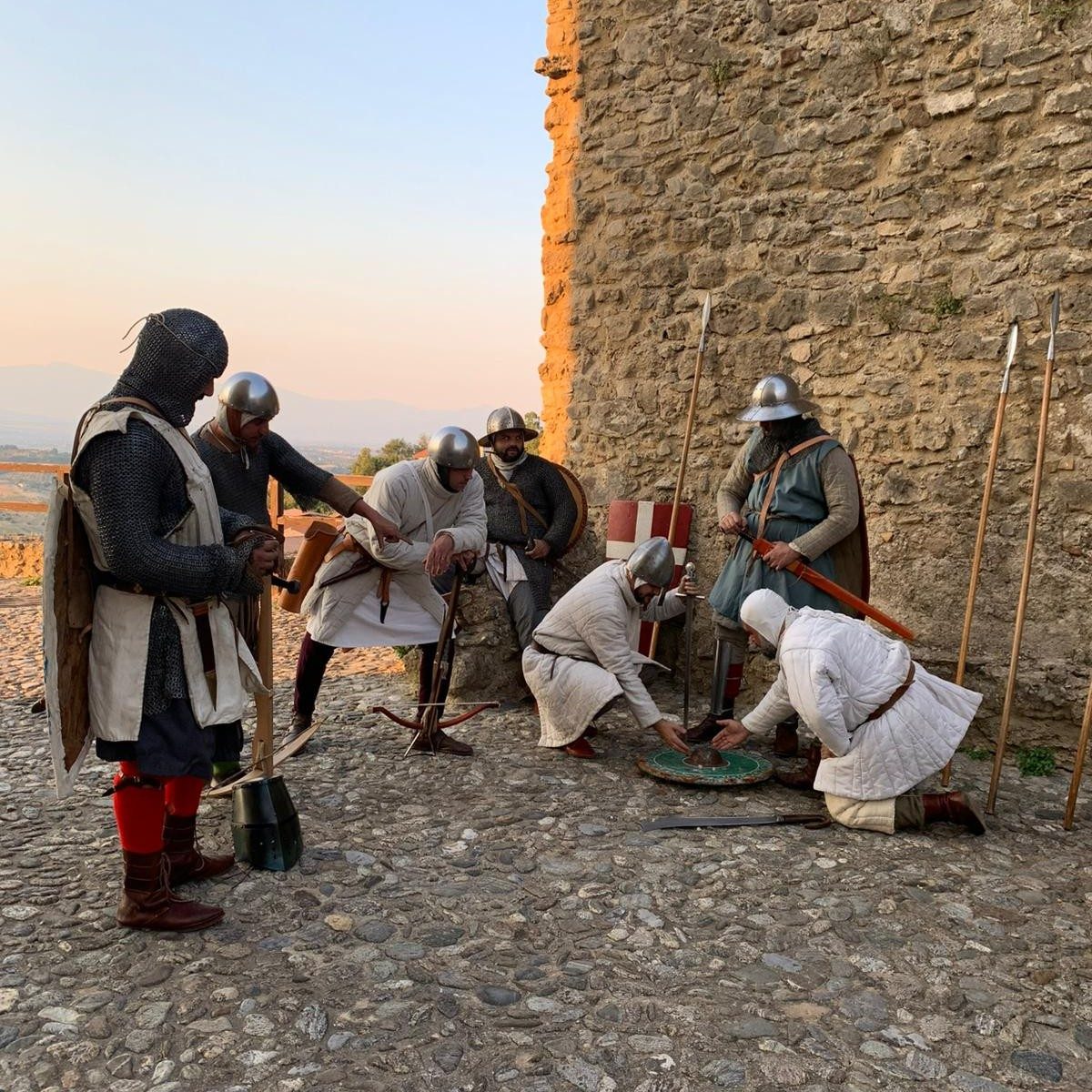 Rievocatori in armatura presso le mura al tramonto