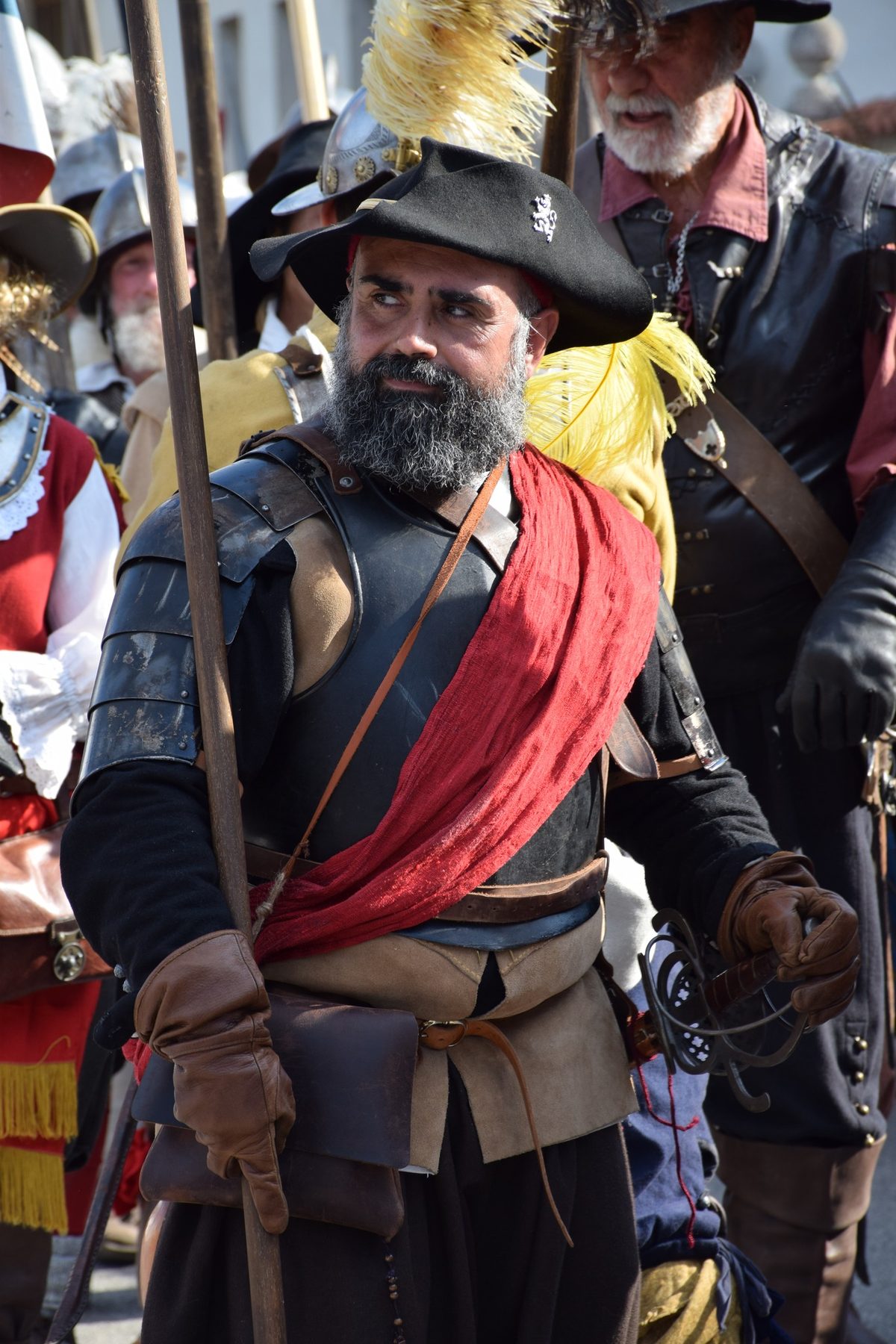 Ritratto di rievocatore con fascia rossa e cappello piumato